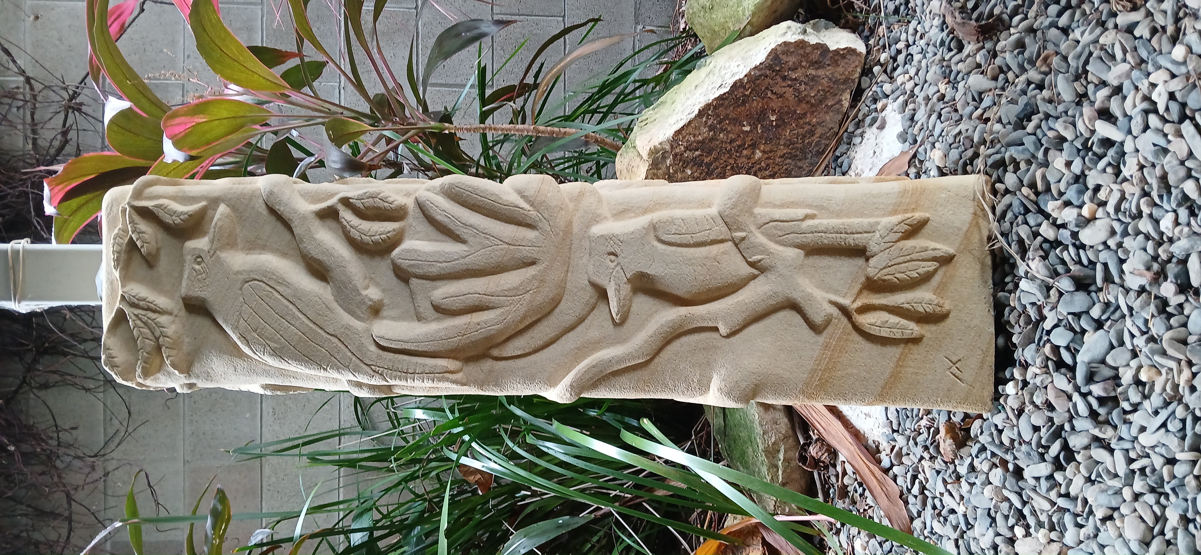 Sandstone pillar with native flora and fauna relief
